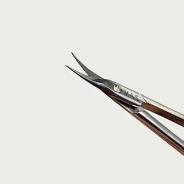 A close-up of a professional scissor with curved blades, showing the tip and handle.