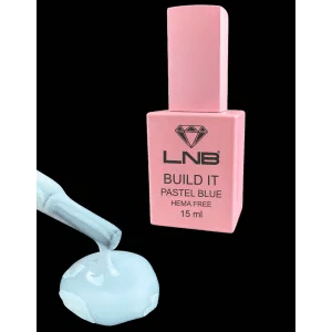 A small bottle of pastel blue nail polish with a pink label, named 'BUILD IT PASTEL BLUE HEMA FREE 15 ml'. The polish is shown both in the bottle and applied to a nail.